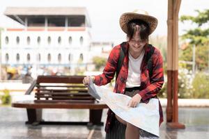 jeune femme voyageuse avec sac à dos à la recherche de carte en attendant le train, routard asiatique sur la plate-forme ferroviaire à la gare. vacances, voyage, voyage et été concept de voyage d'été photo