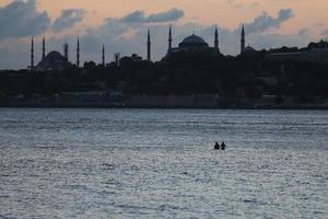 Les nageurs se tiennent debout et se reposent dans le détroit du Bosphore, Istanbul, Turquie photo