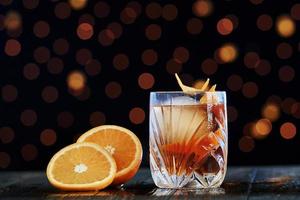 oranges fraîches. le cocktail est prêt. sur la table en bois dans la boîte de nuit. bel éclairage