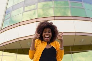 l'heureuse et jeune femme afro-américaine dans la rue s'amusant photo