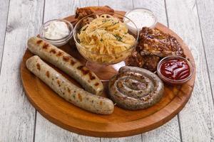 assiette de viande avec saucisses grillées, côtes levées et ailes de poulet photo