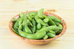 edamame frais cuit à la vapeur saupoudré de sel de mer sur une table rustique. photo