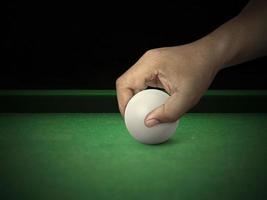 la main met la boule de billard sur la table de billard photo