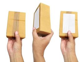 main tenant le paquet de boîte de papier brun isolé sur fond blanc photo
