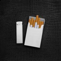 Paquet de cigarettes et briquets sur fond de cuir noir photo