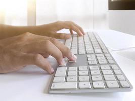 homme assis au bureau et travaillant à l'ordinateur les mains se bouchent photo