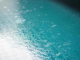 l'eau bleue dans l'arrière-plan de la piscine ondule sur la texture de la surface, l'abstrait bokeh scintillant photo