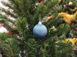 les décorations d'arbre vert de noël décorées ont une boule bleue, des feuilles d'or sur fond flou