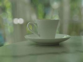 tasse à café posée sur une table en marbre, bokeh avec arrière-plan flou photo