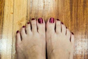 pieds de femmes après pédicure avec des ongles rouges photo