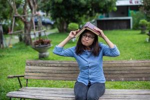 une femme assise dans le jardin en lisant un livre. photo