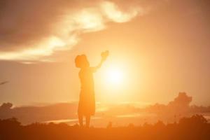 silhouette d'enfant, moments de joie de l'enfant. sur le coucher de soleil nature photo