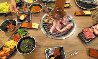 ensemble complet de boeuf et de porc prêt à griller sur la cuisinière avec légumes, tteokbokki, poulet frit et plat d'accompagnement, barbecue de style coréen, mise au point sélective photo