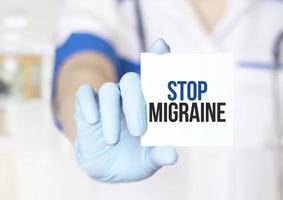 médecin tenant une carte avec texte arrêter la migraine, concept médical photo