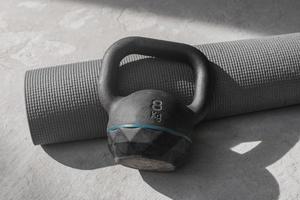 kettlebell et tapis de yoga sur le sol à la maison. équipement de gym. photo