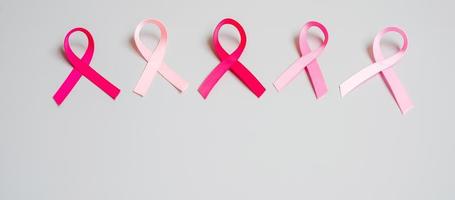 octobre mois de sensibilisation au cancer du sein, ruban rose sur fond gris pour soutenir les personnes vivant et malades. concept de la journée internationale des femmes, des mères et du cancer photo