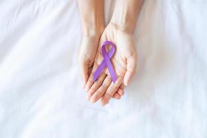 cancer du pancréas, testicule, alzheimer mondial, épilepsie, lupus et mois de sensibilisation à la journée de la violence, femme tenant un ruban violet pour soutenir les personnes vivant. concept de soins de santé et de la journée mondiale du cancer photo