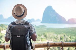 un voyageur heureux profite du point de vue de la baie de phang nga, seul touriste se détendant à samet nang elle, près de phuket dans le sud de la thaïlande. concept de voyage, de voyage et de vacances d'été en asie du sud-est photo