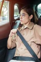 femme conductrice main attachant la ceinture de sécurité pendant qu'elle est assise à l'intérieur d'une voiture et conduit sur la route. concept de sécurité, de voyage, de voyage et de transport photo