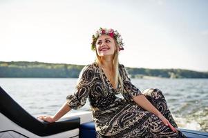 fille blonde en couronne assise sur un yacht à la fête de poule. photo