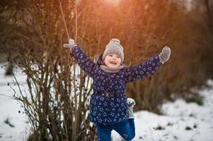 jolie petite fille s'amusant à l'extérieur le jour de l'hiver. photo