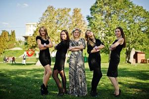 cinq filles portent du noir s'amusant à la fête de poule. photo