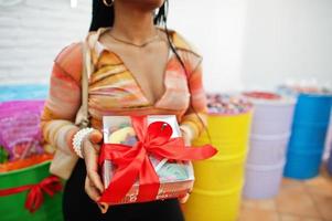 dame afro-américaine du millénaire au magasin de bonbons avec une boîte actuelle de bonbons. photo