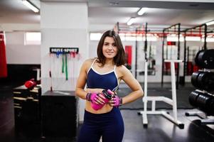 belle jeune femme faisant des exercices et travaillant dur dans la salle de gym et appréciant son processus d'entraînement. photo