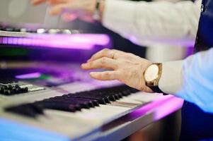 main du claviériste sur scène avec des lumières. photo