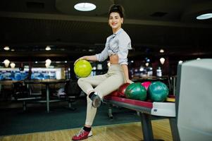 fille avec boule de bowling sur l'allée a joué au club de bowling. photo