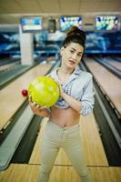 fille avec boule de bowling sur l'allée a joué au club de bowling. photo