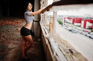 vêtements de fille sur des shorts dans une usine abandonnée avec des murs de briques. photo