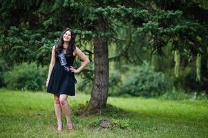 portrait d'une magnifique fille vêtue de noir à la fête de poule, posée au parc. photo