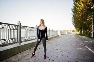 la jeune fille a la formation et fait de l'exercice à l'extérieur. sport, fitness, concept d'entraînement de rue. photo