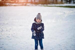 jolie petite fille avec des traîneaux de soucoupe à l'extérieur le jour de l'hiver. photo
