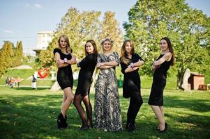 cinq filles portent du noir s'amusant à la fête de poule. photo