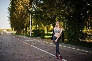 la jeune fille a la formation et fait de l'exercice à l'extérieur. sport, fitness, concept d'entraînement de rue. photo
