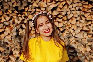 jeune fille drôle avec un maquillage lumineux, porter sur une chemise jaune et une couronne sur fond en bois. photo