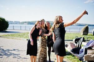 cinq filles portent du noir s'amusant et faisant du selfie à la fête de poule. photo