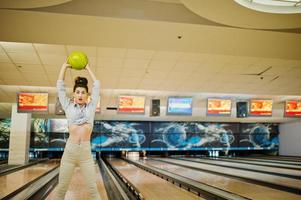 fille avec boule de bowling sur l'allée a joué au club de bowling. photo