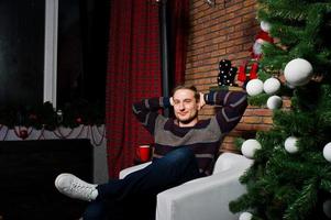 portrait en studio d'homme contre l'arbre de noël avec des décorations. photo