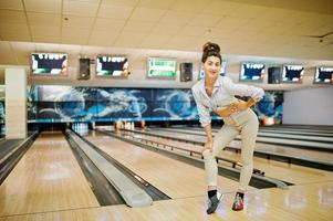 fille avec boule de bowling sur l'allée a joué au club de bowling. photo