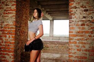vêtements de fille sur des shorts dans une usine abandonnée avec des murs de briques. photo