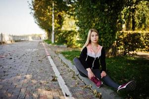 la jeune fille a la formation et fait de l'exercice à l'extérieur. sport, fitness, concept d'entraînement de rue. photo