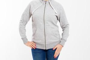 jeune femme hipster portant un sweat-shirt en coton vierge avec une zone pour votre logo, une maquette de sweat à capuche gris pour femme, un mur blanc en arrière-plan avec un espace de copie pour votre conception ou votre contenu photo