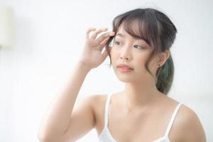 portrait d'une belle jeune femme asiatique sourire tout en se réveillant en bonne santé et bien-être avec le lever du soleil le matin dans la chambre, soins de la peau d'une fille asiatique avec un concept frais, de style de vie et de détente. photo