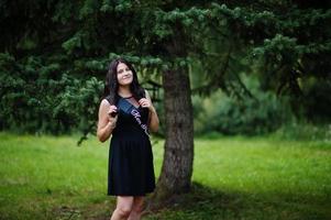 portrait d'une magnifique fille vêtue de noir à la fête de poule, posée au parc. photo