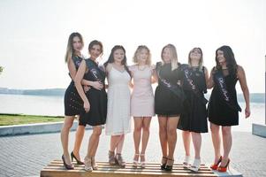 groupe de 7 filles portant du noir et 2 mariées à la fête de poule. photo
