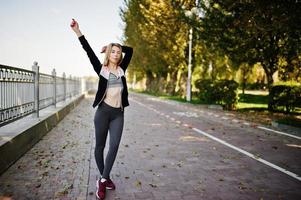 la jeune fille a la formation et fait de l'exercice à l'extérieur. sport, fitness, concept d'entraînement de rue. photo