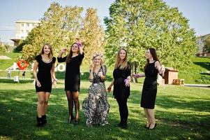 cinq filles portent du noir en sautant à la fête de poule. photo